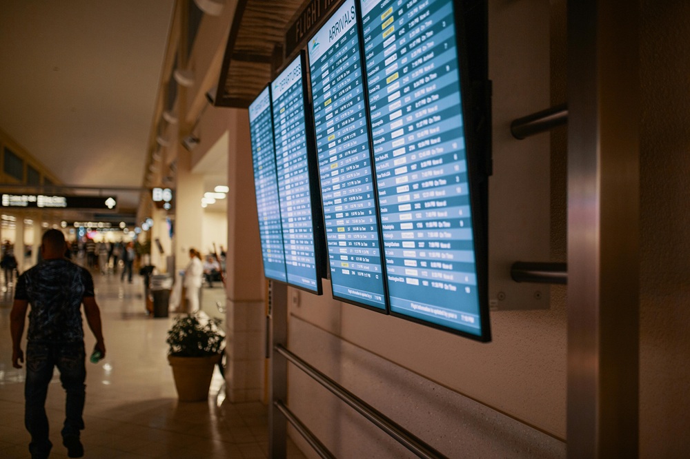 A dark view of departing and arrival times on an airport display.