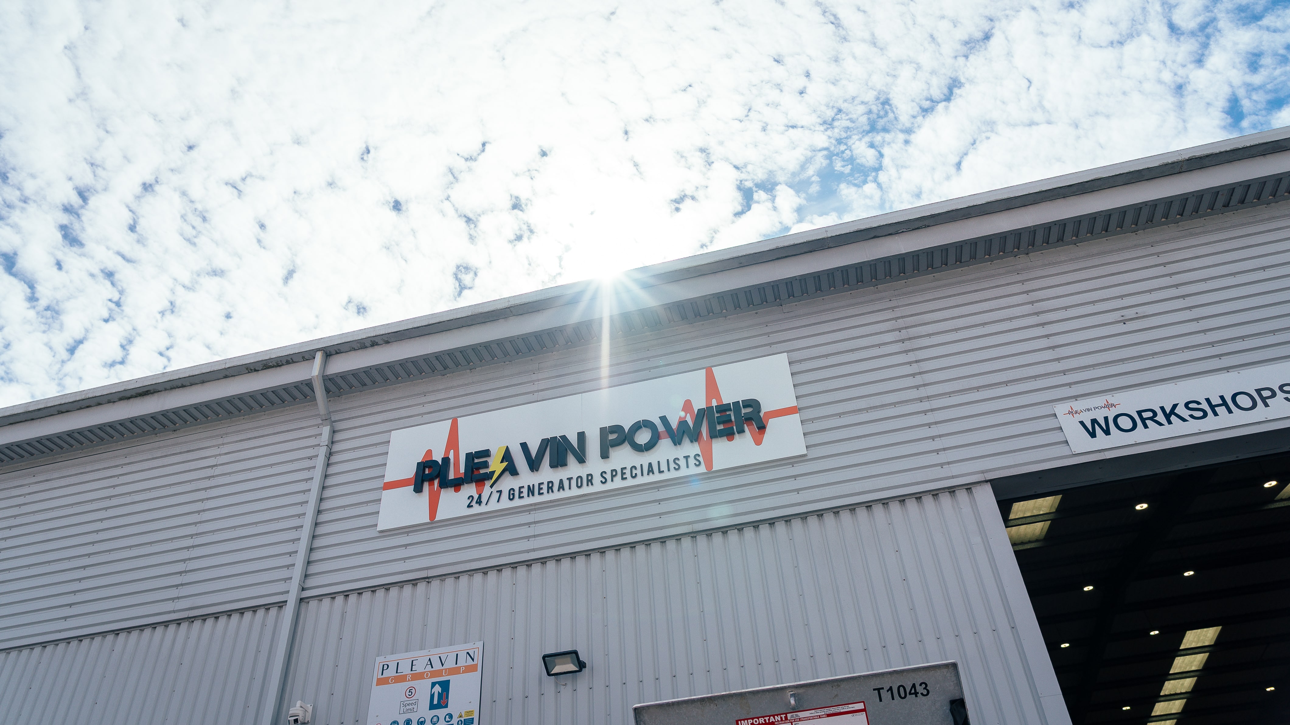 Pleavin Power signage on warehouse with sun behind the building