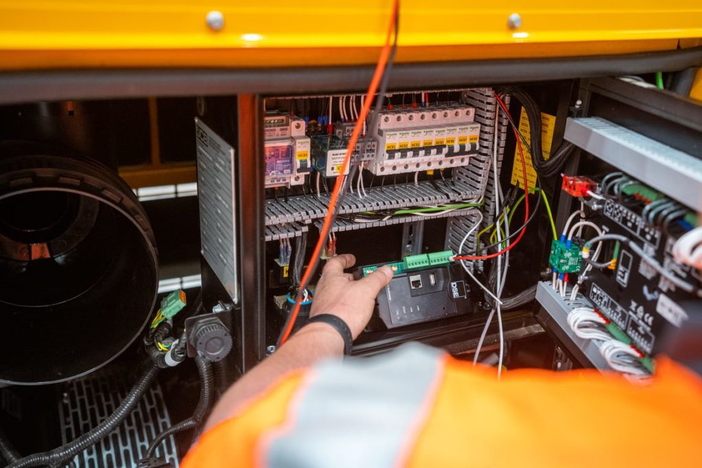 Pleavin power engineer installing an orange generator unit